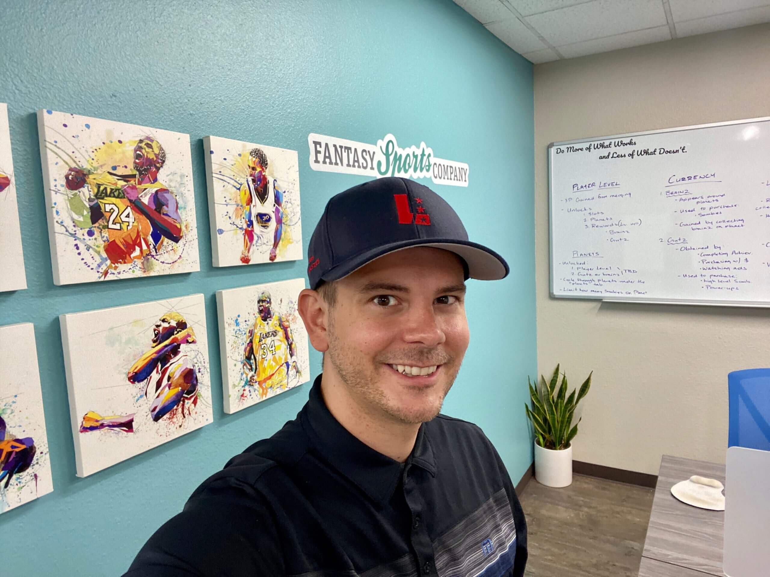 Erik stands in front of an aqua wall inside the Fantasy Sports Co. headquarters