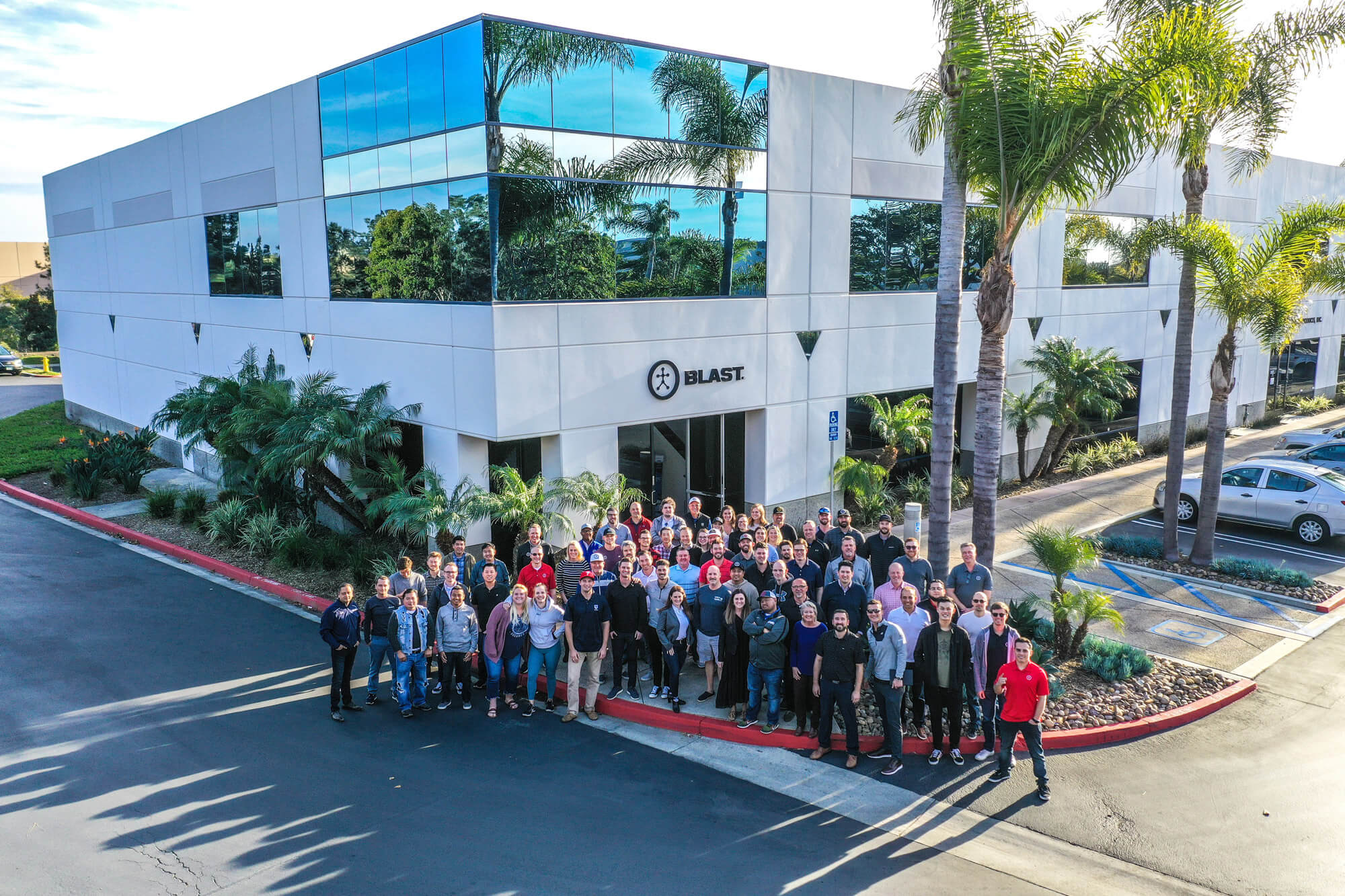 A group of Blast Motion employees stand outside their Carlsbad office building