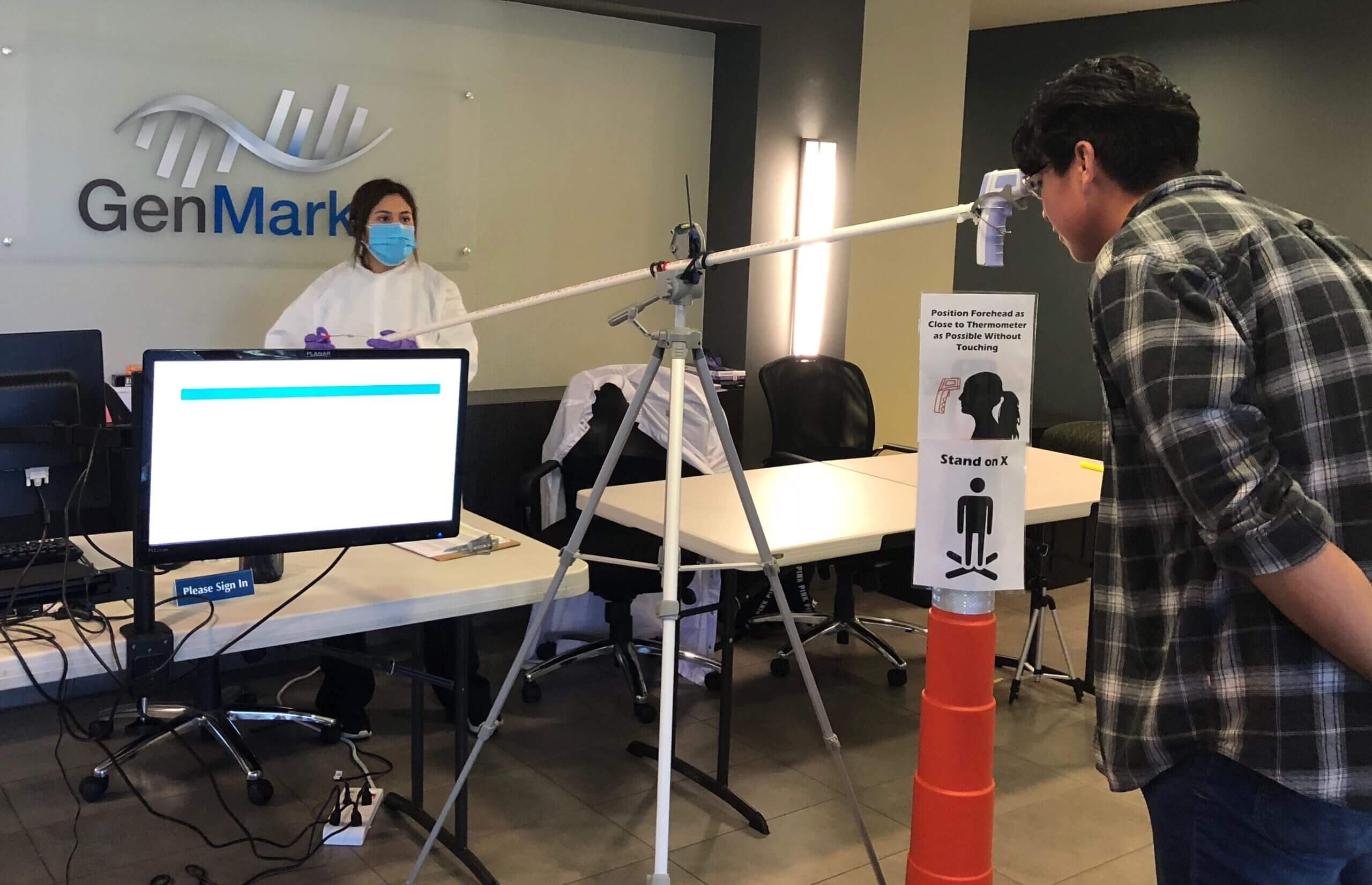 Two employees run an experiment inside GenMark's Carlsbad office